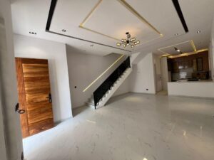 Modern living room connected to an open-concept kitchen with premium finishes.
