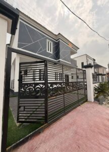 Luxury duplex with secure automated gate, paved driveway, and private compound.