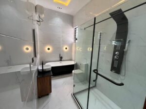 Luxury ensuite bathroom with freestanding bathtub, glass shower enclosure, and premium fittings.